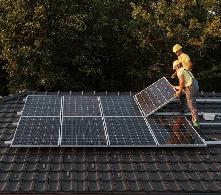 Instaladores posicionando painéis solares em um telhado